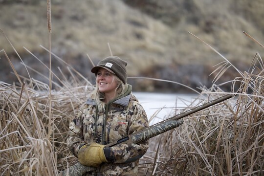 Hayley Larson in the field in hunting gear