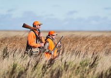 adult and child in tall grass pheasant hunting