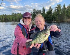 mother and daughter with a crappie on a boat