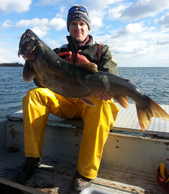 DNR Fisheries staff holding a lake trout on a fisheries boat