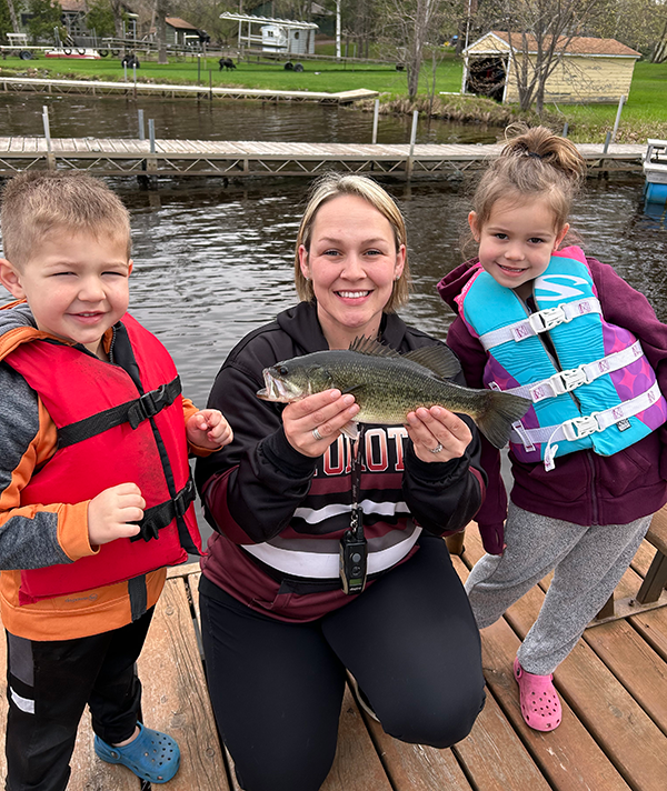 family fishing with two kids and an adult on a dock