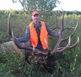 elk hunter with large racked elk he harvested