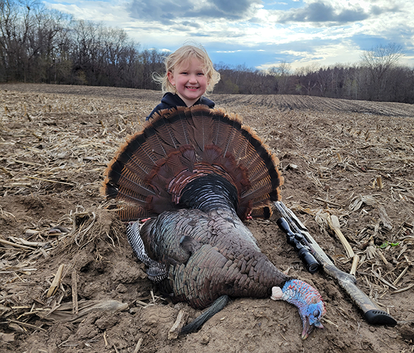 young turkey hunter holding a turkey harvested