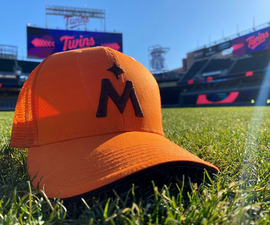 orange Twins hat on the field, up close photo