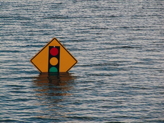 A road sign half hidden by flood waters