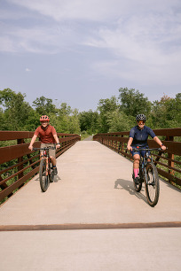 Two cyclists on a bridge on a trail.