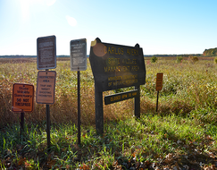 various signs at an access to Carlos Avery WMA