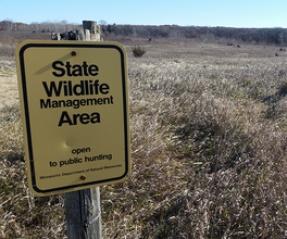 State Wildlife Management Area sign with grass in the background