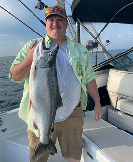 angler holding a state record coho salmon caught on Lake Superior this year