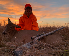 hunter with a muzzleloader on the deer he harvested