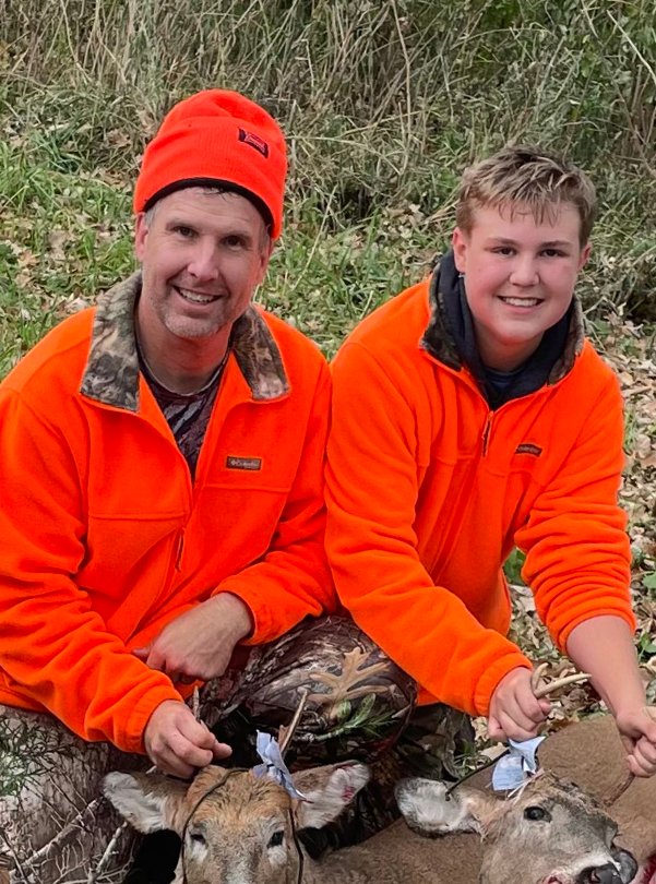 father and son with deer they harvested