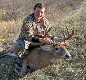 hunter with a large buck he harvested at the Camp Ripley archery hunt