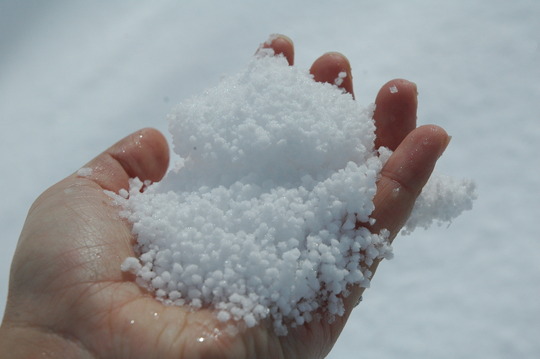 A hand filled with small balls of snow