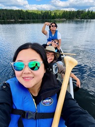 A Hmong outdoors leader and her youth group in a canoe on a lake in Northern Minnesota.