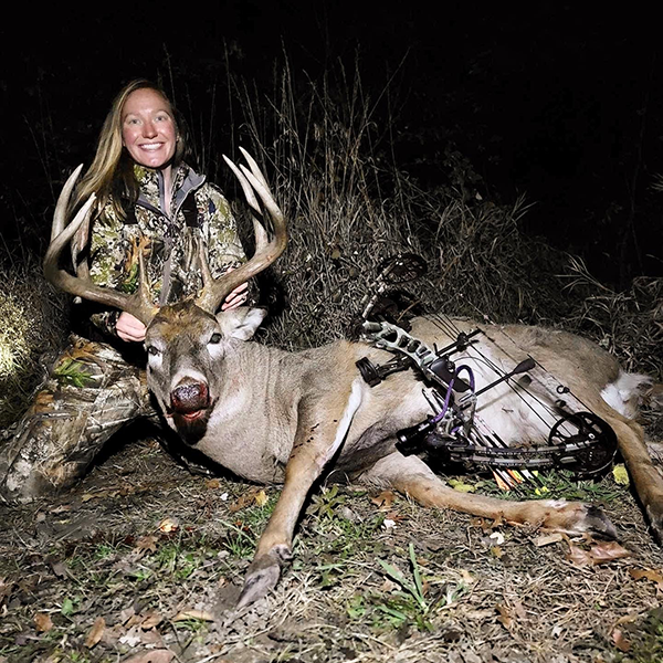 archery hunter with a large buck she harvested