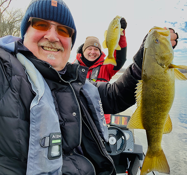 two anglers holding smallmouth bass