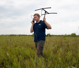 college student with radio equipment doing wildlife research 