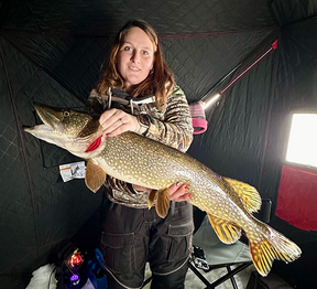 angler with large northern pike caught ice fishing