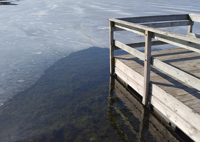 a fishing pier with ice and open water