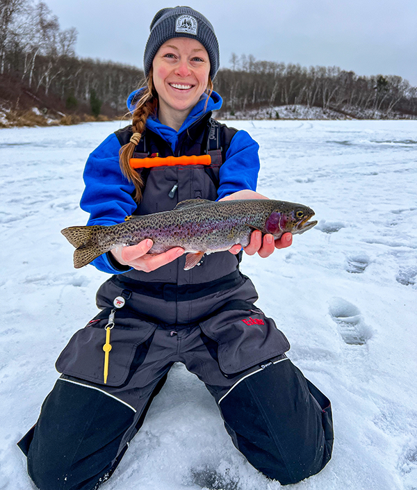 angler holding a trout caught through the ice