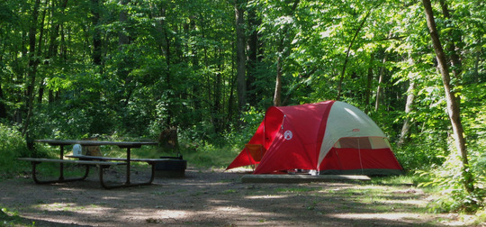 a photo of a red tent at a drive-in campsite