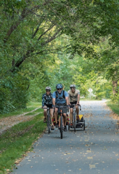 three bikers on a state trail, packed with gear for camping