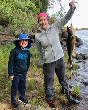 woman with walleye she caught and a kid next to her
