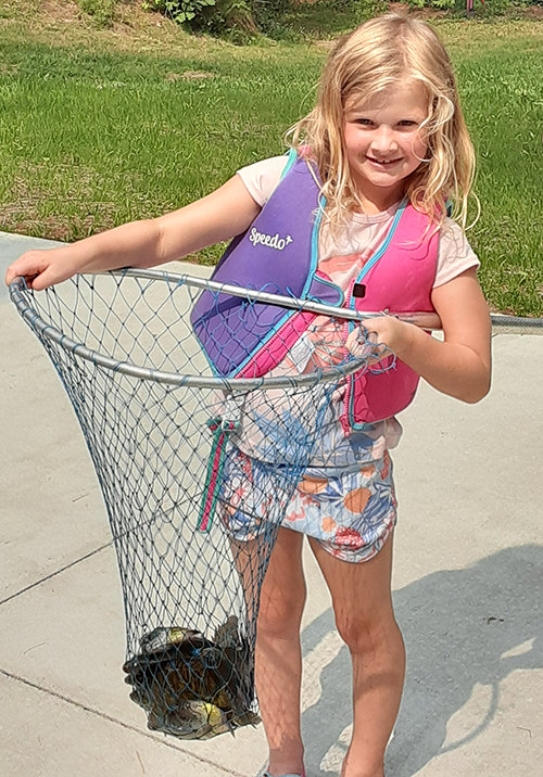 smiling girl with a net full of panfish 