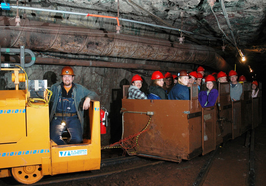 In an underground mine, a train carts people along a track. 