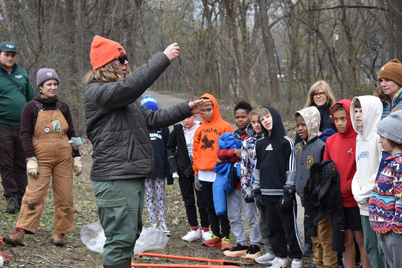 A person showing kids how to care for trees in their communities