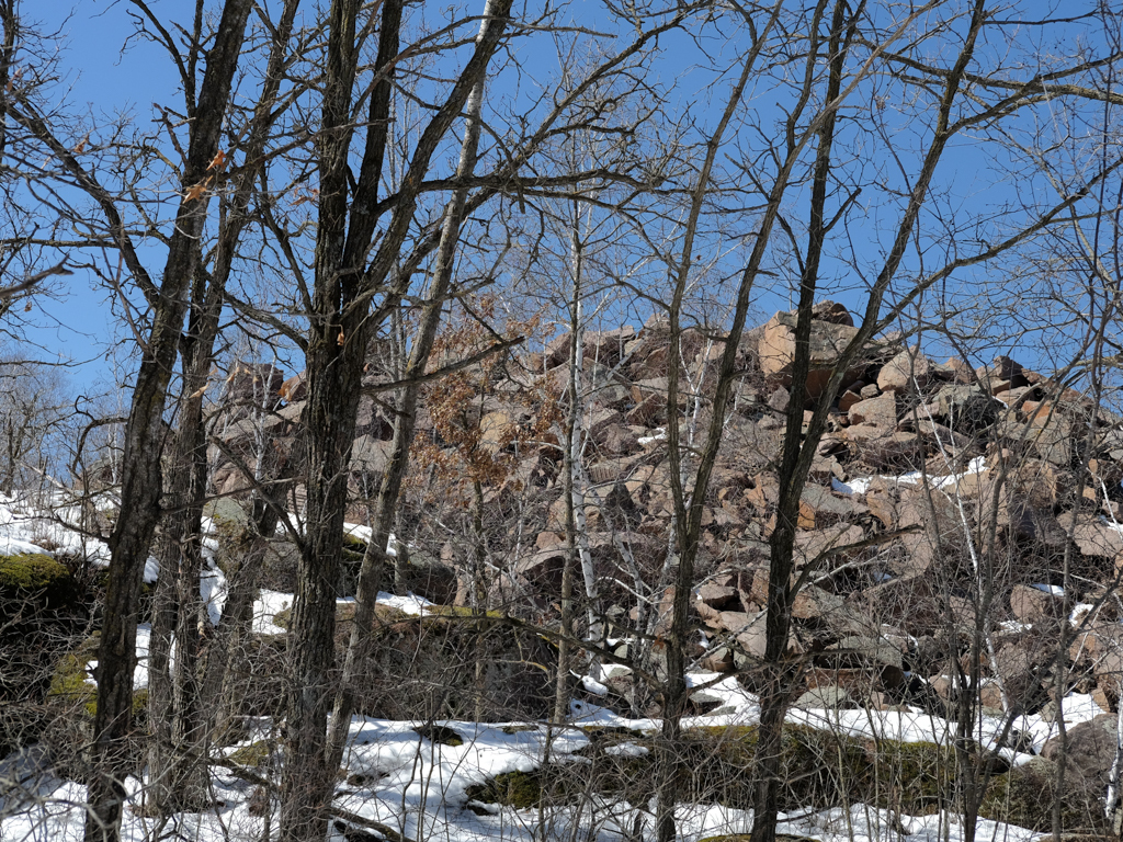A pile of granite boulders as seen through the trees at Quarry Park and Nature Preserve