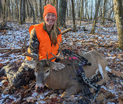 archery hunter wearing blaze orange with deer she harvested