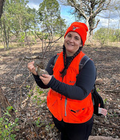 photo of hunter in blaze orange holding squirrel she harvested