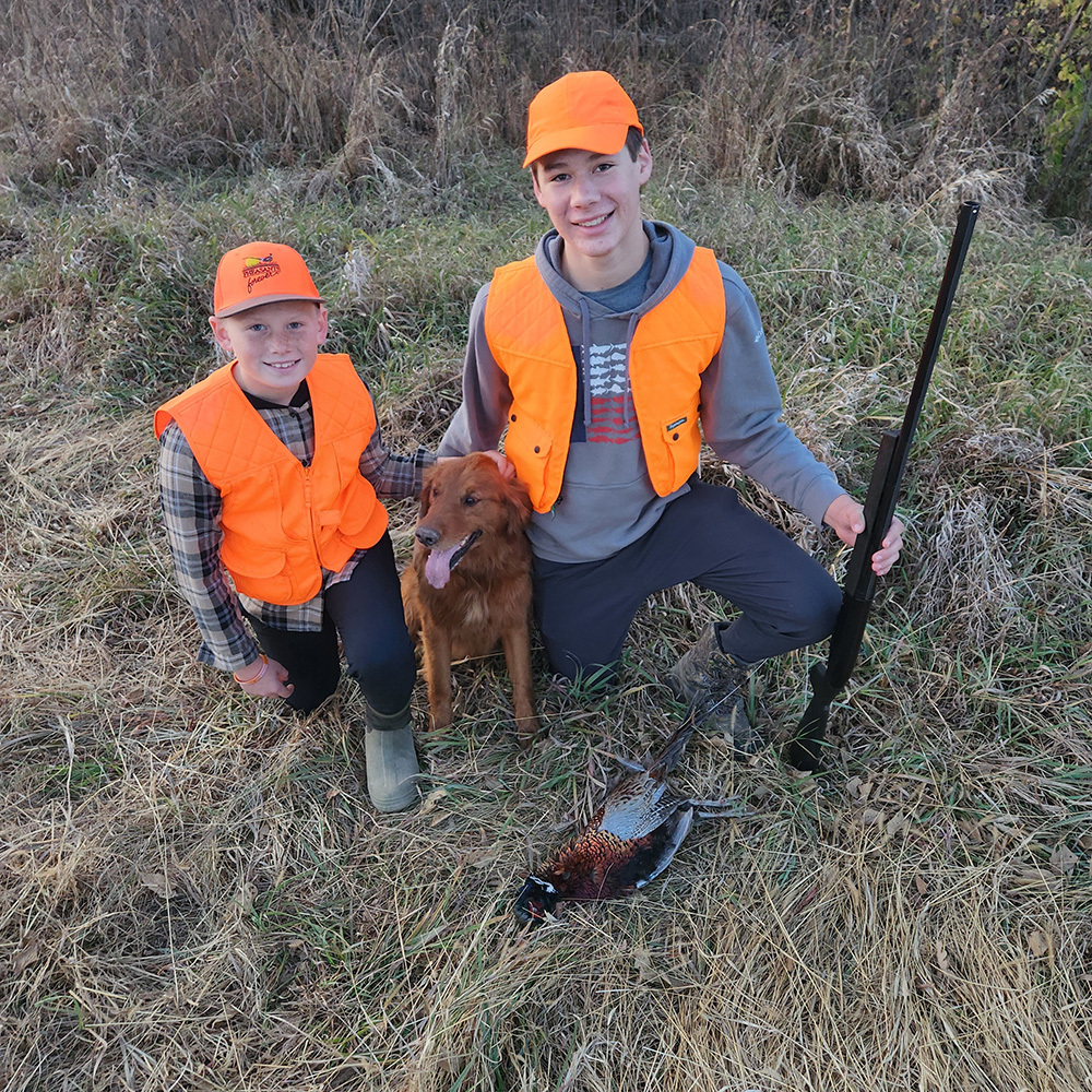 two young pheasant hunters and a dog, and pheasant harvested