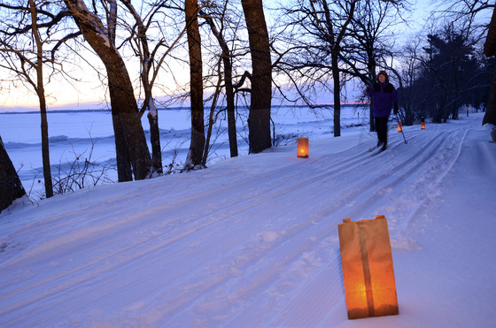 A person skiing by candlelight on a trail