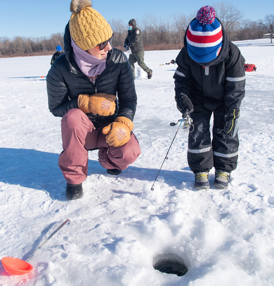 An adult and a kid ice fishing