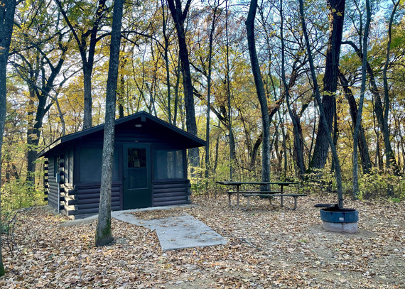 A camper cabin surrounded by golden trees.