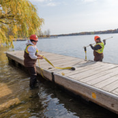 Two workers install a dock section. 