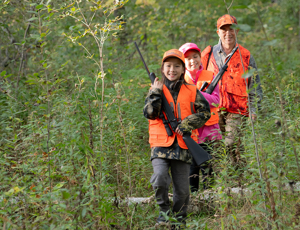 Hmong hunters walking in a green woodsy scene