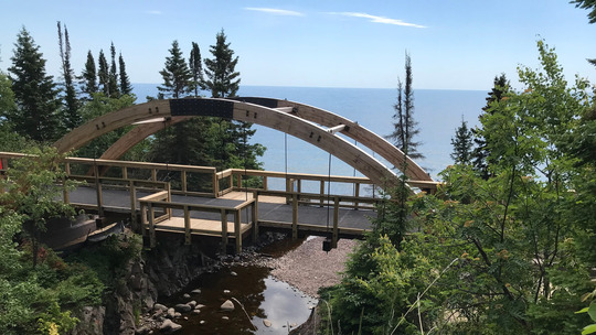 An arching bridge stretches over a river gorge. 
