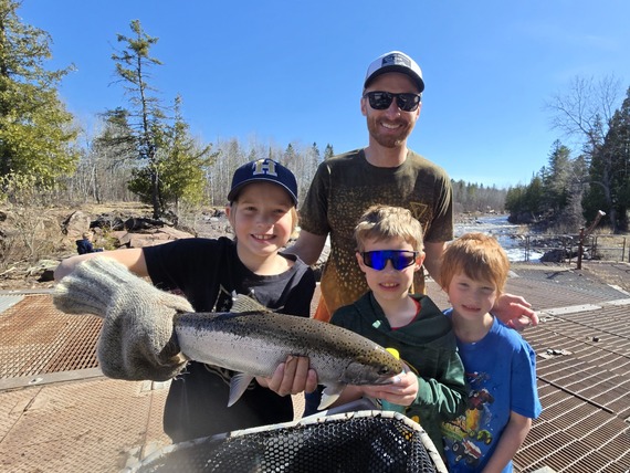 Happy 1st graders holding a steelhead