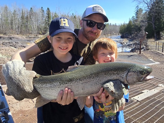 Happy family holding a large steelhead at Knife River trap