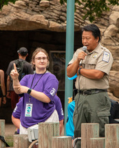 A state park naturalist speaks into a microphone while an ASL interpreter signs next to them.