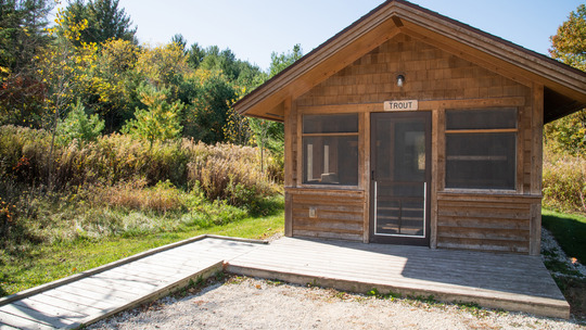 A camper cabin has a long, gently sloping ramp leading up to the front door.
