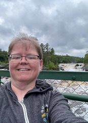 Jenna takes a selfie on the Jay Cooke swinging bridge with a river in the background. 