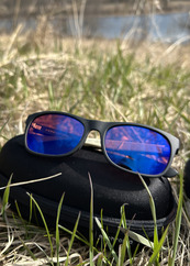 A pair of glasses with blue lenses sit outside. 