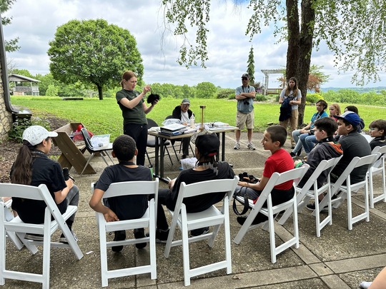 children watching a naturalist demonstration 
