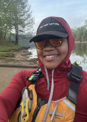 Devin Brown smiles for a selfie while wearing a life jacket and sunglasses. 