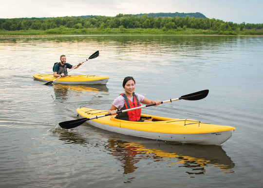 Two people kayak on a calm day at Frontenac State Park. 