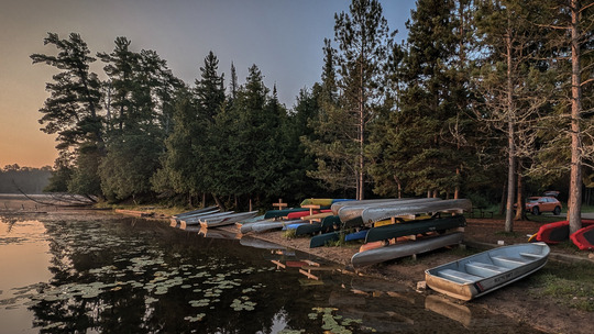 A variety of rental boats, kayaks, and paddleboards lay along the shoreline.